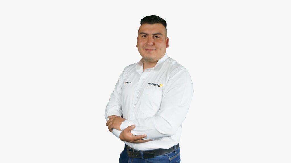 Portrait of a man in a white shirt with company logos, arms crossed and smiling against a light background.