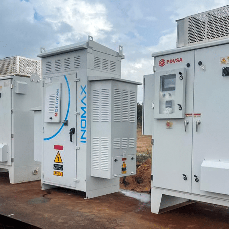 Outdoor industrial electrical switchgear cabinets on a dirt lot, with PDVSA branding visible on the right panel.